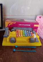 Close-up of the precisely tuned, colorful xylophone bars on the car-shaped musical toy.