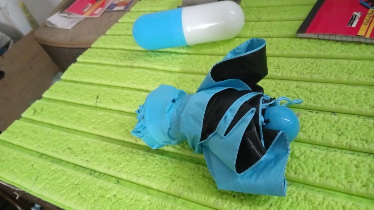 A hand holding the compact 5-Fold Umbrella, illustrating its small, travel-friendly size.