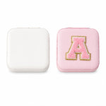The LilyGleam travel jewellery box placed next to travel essentials like a passport and sunglasses.