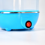 Three-layer electric egg steamer with transparent lid and measuring cup.