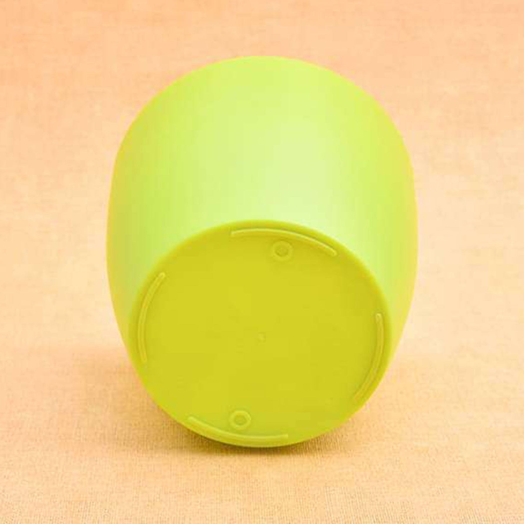 Green round plastic planter with a plant, showcasing its sturdy design for gardening.